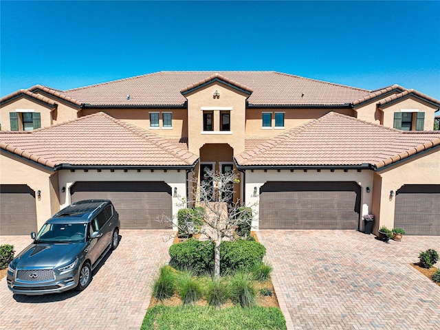 23527 Awabuki Unit 202, Venice, FL 34293 - view of front of property featuring an attached garage, stucco siding, decorative driveway, and a tiled roof