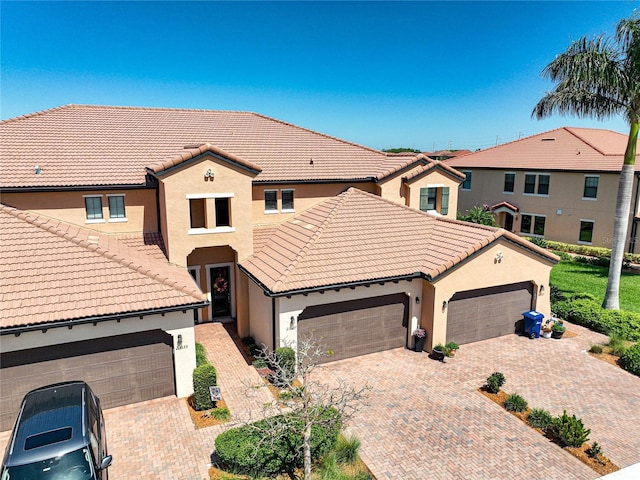 23527 Awabuki Unit 202, Venice, FL 34293 - view of front of property with a tiled roof, stucco siding, decorative driveway, and an attached garage