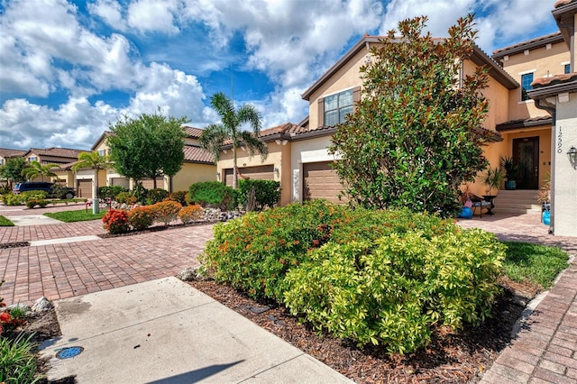 12590 Ghiberti Cir Unit 201, Venice, FL 34293 - view of front facade featuring stucco siding, a tiled roof, and a garage