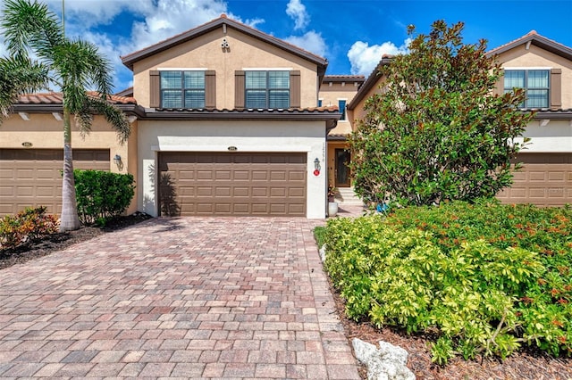 12590 Ghiberti Cir Unit 201, Venice, FL 34293 - view of front of house featuring stucco siding, a garage, decorative driveway, and a tiled roof