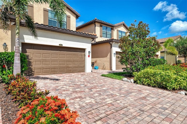 12590 Ghiberti Cir Unit 201, Venice, FL 34293 - mediterranean / spanish home with stucco siding, an attached garage, and decorative driveway