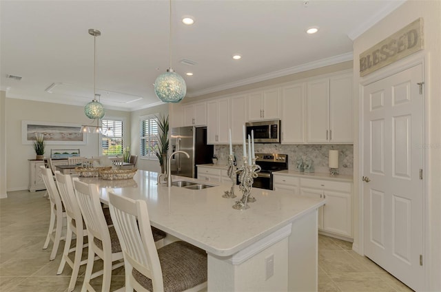12590 Ghiberti Cir Unit 201, Venice, FL 34293 - kitchen with stainless steel appliances, crown molding, white cabinetry, a spacious island, and recessed lighting