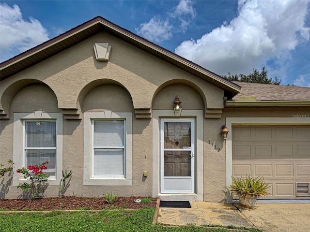 3139 Point St, North Port, FL 34286 - property entrance with stucco siding and an attached garage