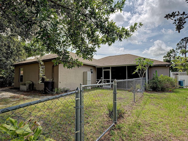 3139 Point St, North Port, FL 34286 - rear view of house featuring a gate, a sunroom, and stucco siding