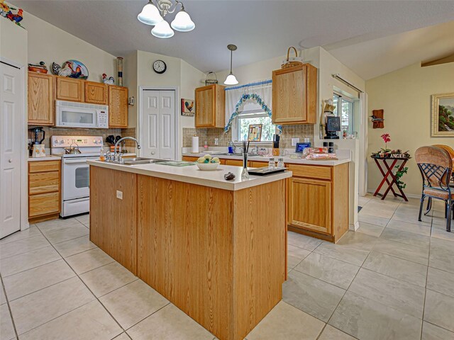 3139 Point St, North Port, FL 34286 - kitchen featuring white appliances, lofted ceiling, decorative backsplash, a kitchen island with sink, and light countertops