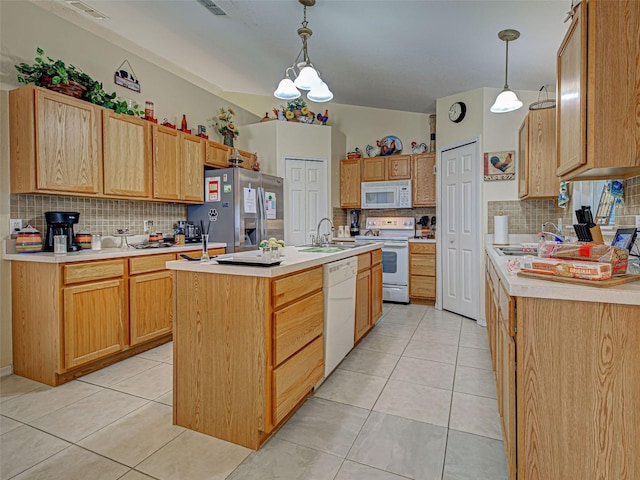 3139 Point St, North Port, FL 34286 - kitchen featuring white appliances, a kitchen island with sink, tasteful backsplash, and light countertops