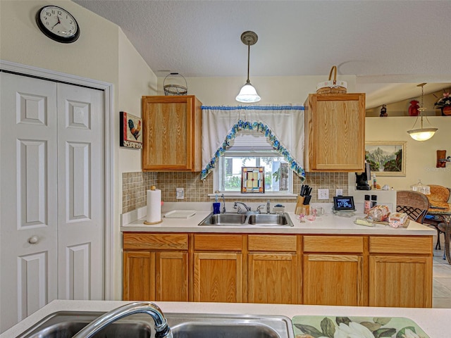 3139 Point St, North Port, FL 34286 - kitchen featuring decorative backsplash, pendant lighting, light countertops, a textured ceiling, and vaulted ceiling