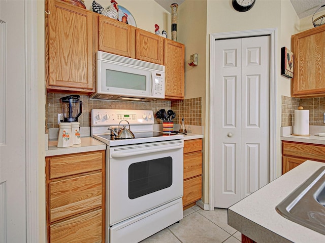 3139 Point St, North Port, FL 34286 - kitchen featuring white appliances, light tile patterned flooring, decorative backsplash, and light countertops