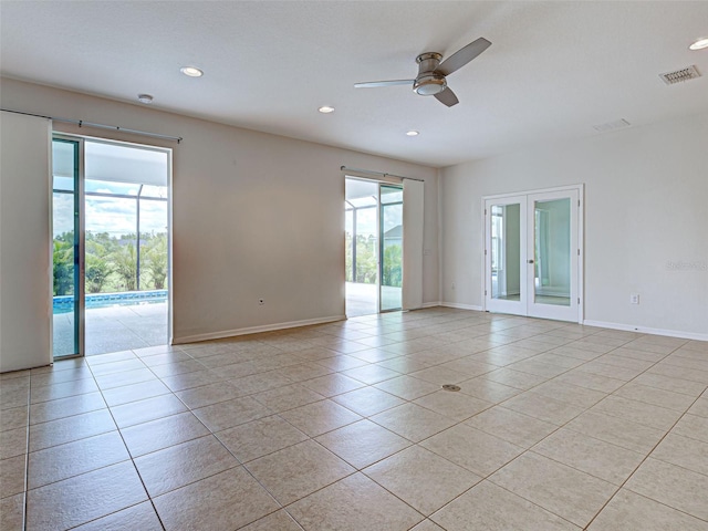 9157 Genesee St, Port Charlotte, FL 33981 - empty room with light tile patterned flooring, ceiling fan, recessed lighting, and french doors