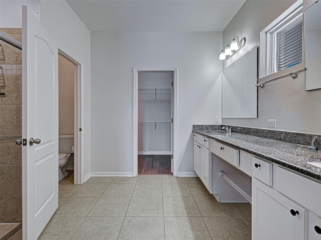 9157 Genesee St, Port Charlotte, FL 33981 - bathroom with double vanity, tiled shower, tile patterned flooring, and a walk in closet