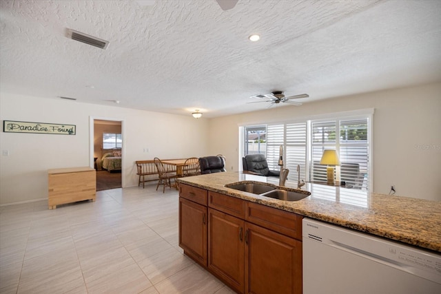 2941 Datura Rd, Venice, FL 34293 - kitchen featuring white dishwasher, ceiling fan, brown cabinetry, a textured ceiling, and light stone countertops