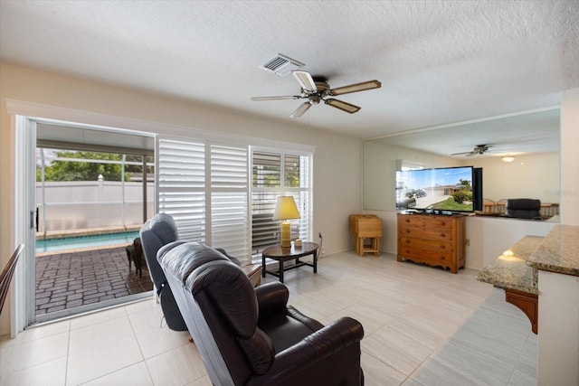 2941 Datura Rd, Venice, FL 34293 - living room with ceiling fan, a textured ceiling, and light tile patterned floors