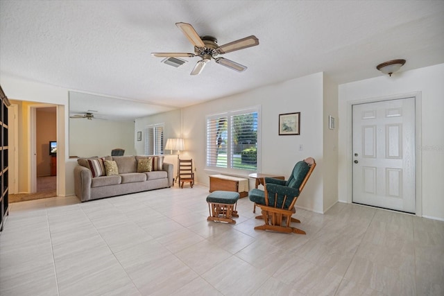 2941 Datura Rd, Venice, FL 34293 - living room with ceiling fan, a textured ceiling, and light tile patterned floors