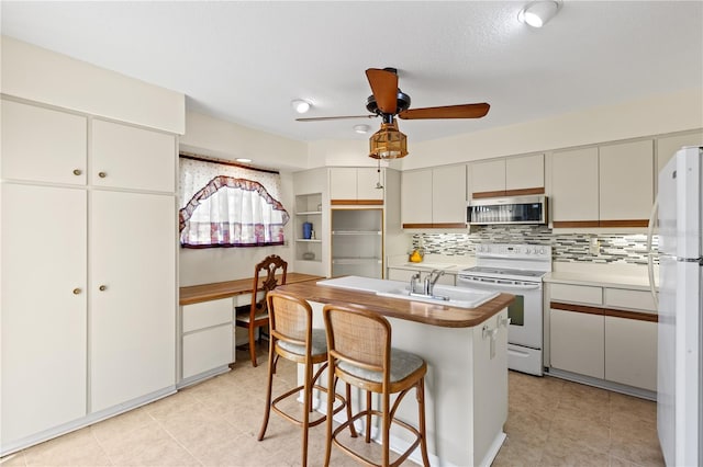 1315 Pine Needle Rd, Venice, FL 34285 - kitchen featuring white appliances, backsplash, a kitchen bar, a ceiling fan, and light tile patterned floors