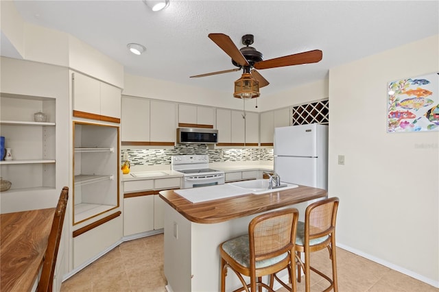 1315 Pine Needle Rd, Venice, FL 34285 - kitchen featuring white appliances, ceiling fan, decorative backsplash, light tile patterned floors, and a center island with sink