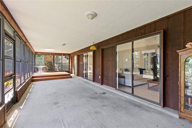 1315 Pine Needle Rd, Venice, FL 34285 - unfurnished sunroom with wooden walls, carpet, and plenty of natural light