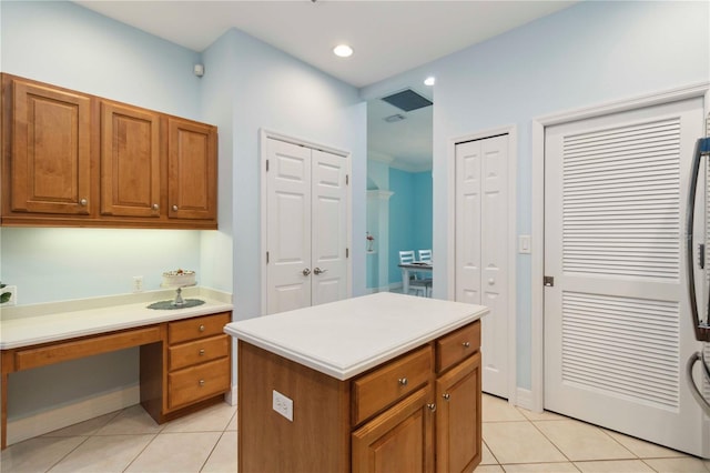 6619 Pinefeather Ct, Bradenton, FL 34203 - kitchen with light tile patterned flooring, brown cabinets, light countertops, and a center island