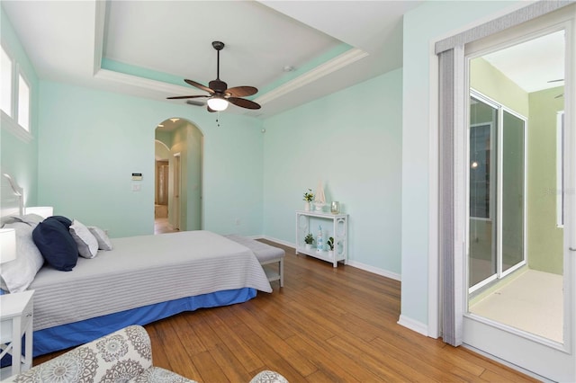 6619 Pinefeather Ct, Bradenton, FL 34203 - bedroom featuring arched walkways, a tray ceiling, hardwood / wood-style floors, and a ceiling fan