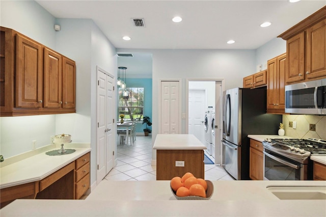 6619 Pinefeather Ct, Bradenton, FL 34203 - kitchen with appliances with stainless steel finishes, a center island, backsplash, recessed lighting, and light tile patterned floors