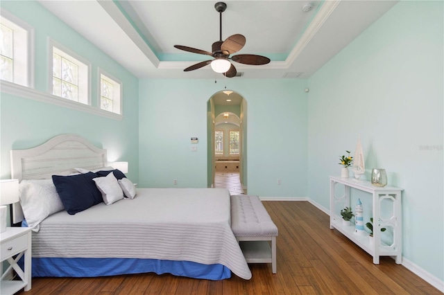 6619 Pinefeather Ct, Bradenton, FL 34203 - bedroom with a tray ceiling, multiple windows, arched walkways, and wood finished floors