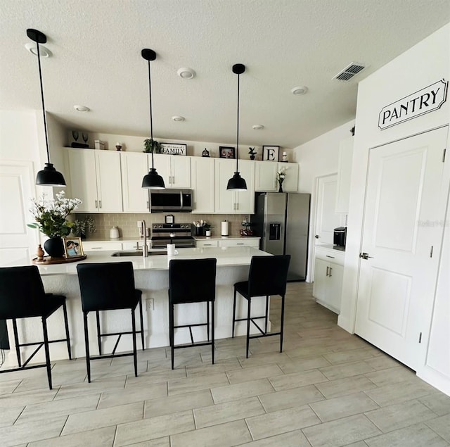 4033 Union Ln, North Port, FL 34288 - kitchen featuring stainless steel appliances, tasteful backsplash, a textured ceiling, light countertops, and a kitchen bar