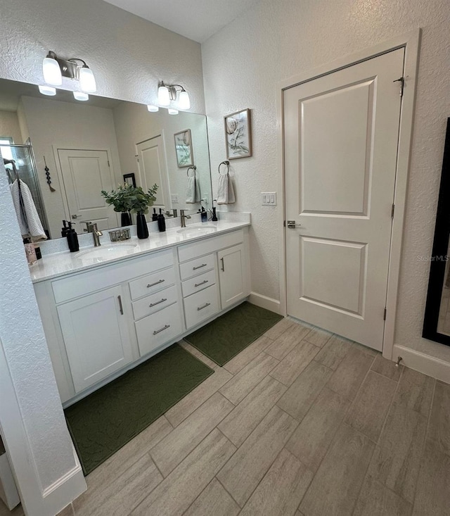 4033 Union Ln, North Port, FL 34288 - bathroom with a textured wall, wood tiled floors, and double vanity
