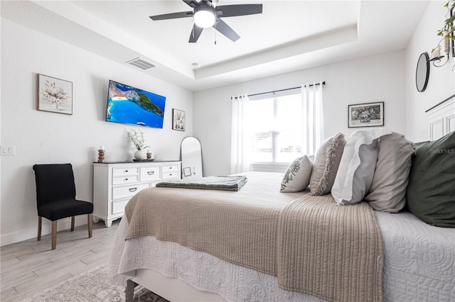 4033 Union Ln, North Port, FL 34288 - bedroom featuring a raised ceiling, light wood finished floors, and a ceiling fan