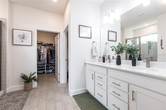 4033 Union Ln, North Port, FL 34288 - full bath with double vanity, a walk in closet, a shower stall, and wood finished floors