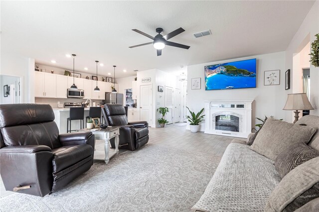 4033 Union Ln, North Port, FL 34288 - living area with ceiling fan, a high end fireplace, light wood-type flooring, and recessed lighting