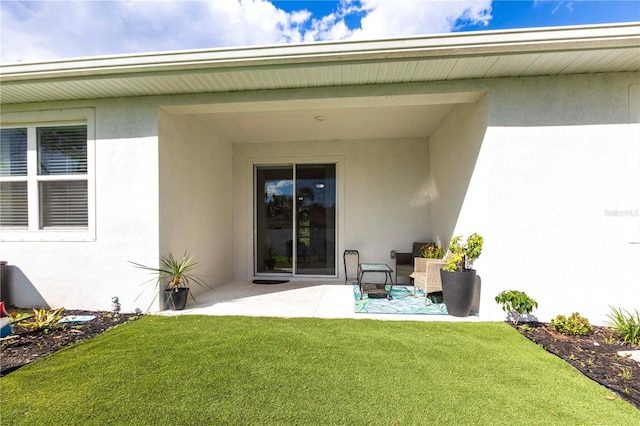 4033 Union Ln, North Port, FL 34288 - back of property featuring stucco siding, a patio, and a lawn