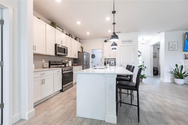 4033 Union Ln, North Port, FL 34288 - kitchen featuring appliances with stainless steel finishes, decorative backsplash, a kitchen bar, white cabinets, and recessed lighting