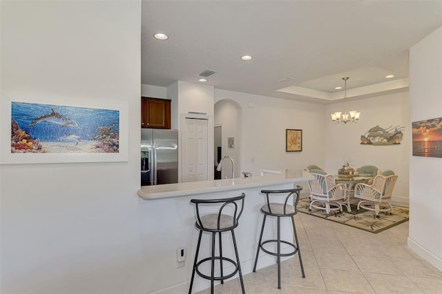 371 Capulet Dr, Venice, FL 34292 - kitchen featuring stainless steel fridge, arched walkways, recessed lighting, a peninsula, and light tile patterned flooring