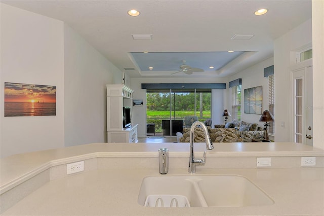 371 Capulet Dr, Venice, FL 34292 - kitchen featuring a tray ceiling, ceiling fan, recessed lighting, open floor plan, and light countertops
