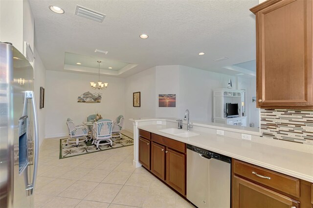 371 Capulet Dr, Venice, FL 34292 - kitchen featuring appliances with stainless steel finishes, decorative backsplash, light tile patterned floors, light countertops, and a chandelier