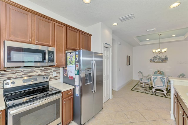 371 Capulet Dr, Venice, FL 34292 - kitchen featuring appliances with stainless steel finishes, a chandelier, backsplash, light countertops, and brown cabinetry