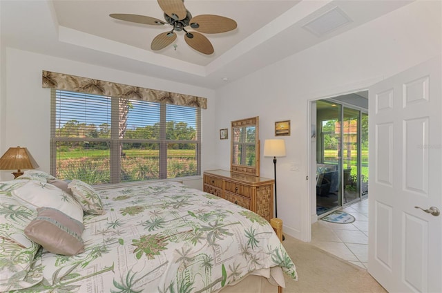 371 Capulet Dr, Venice, FL 34292 - bedroom featuring light tile patterned floors, light colored carpet, ceiling fan, and a tray ceiling