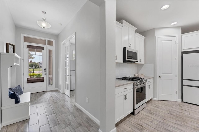 11240 Spring Gate Trl, Bradenton, FL 34211 - kitchen with appliances with stainless steel finishes, white cabinetry, light wood finished floors, backsplash, and recessed lighting