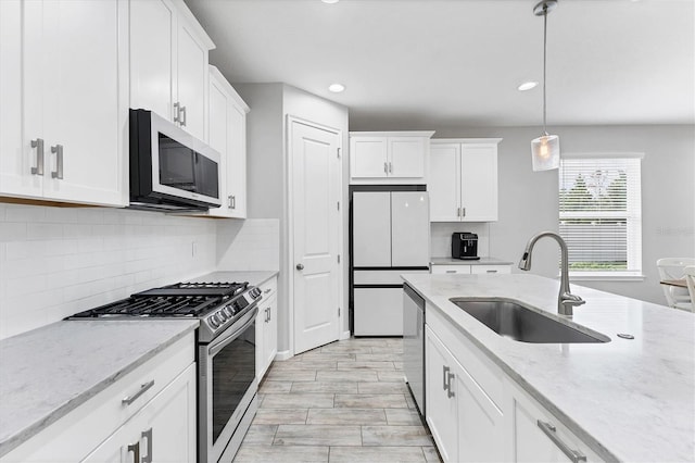 11240 Spring Gate Trl, Bradenton, FL 34211 - kitchen with stainless steel appliances, white cabinets, pendant lighting, light stone countertops, and recessed lighting