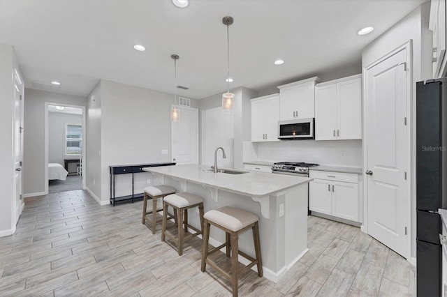 11240 Spring Gate Trl, Bradenton, FL 34211 - kitchen featuring white microwave, freestanding refrigerator, light wood finished floors, white cabinetry, and recessed lighting