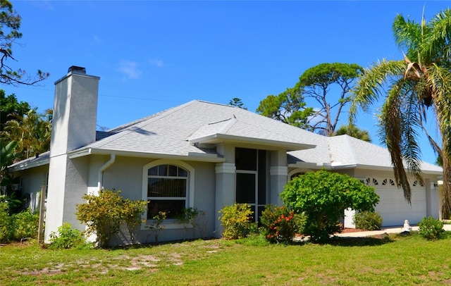 505 Duke Rd, Venice, FL 34293 - view of front facade with a chimney, a garage, a front yard, and stucco siding