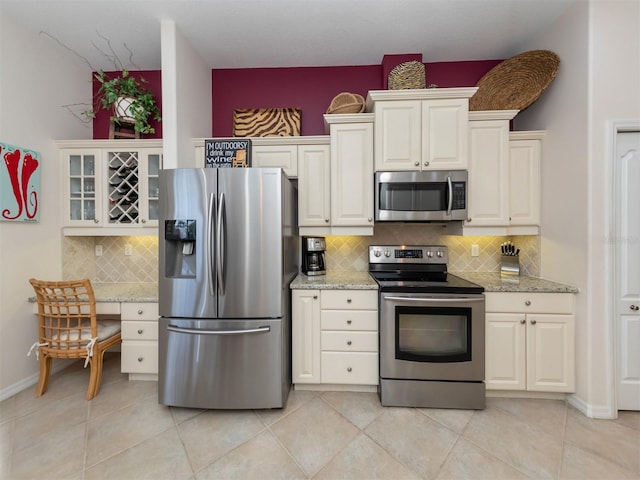 819 Shadow Bay Way, Osprey, FL 34229 - kitchen with stainless steel appliances, decorative backsplash, light stone counters, and glass insert cabinets