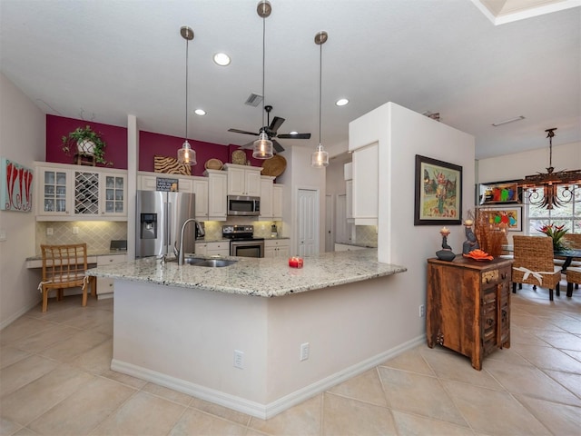 819 Shadow Bay Way, Osprey, FL 34229 - kitchen featuring appliances with stainless steel finishes, decorative backsplash, light tile patterned flooring, white cabinetry, and recessed lighting
