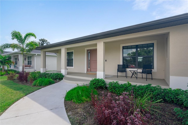 7257 Maguire Ln, Englewood, FL 34224 - view of exterior entry featuring stucco siding and covered porch