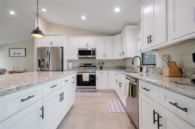 7257 Maguire Ln, Englewood, FL 34224 - kitchen with stainless steel appliances, lofted ceiling, white cabinets, pendant lighting, and light stone counters