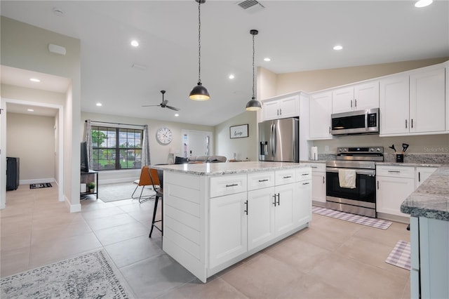 7257 Maguire Ln, Englewood, FL 34224 - kitchen featuring stainless steel appliances, vaulted ceiling, a center island, decorative light fixtures, and light stone countertops