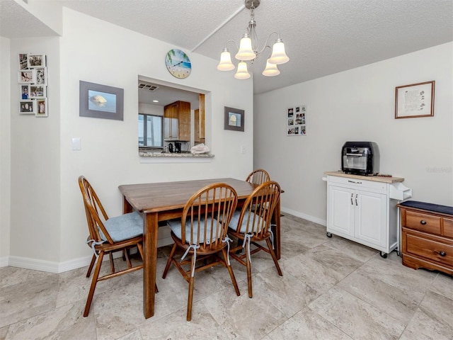 401 Airport Ave E Unit 304, Venice, FL 34285 - dining room featuring a chandelier and a textured ceiling