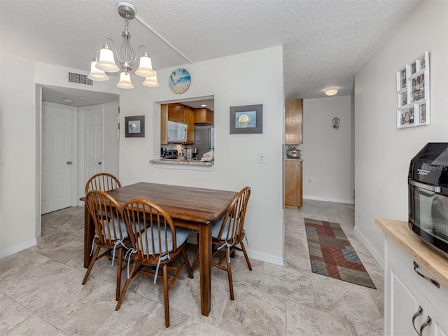 401 Airport Ave E Unit 304, Venice, FL 34285 - dining space with a chandelier and a textured ceiling