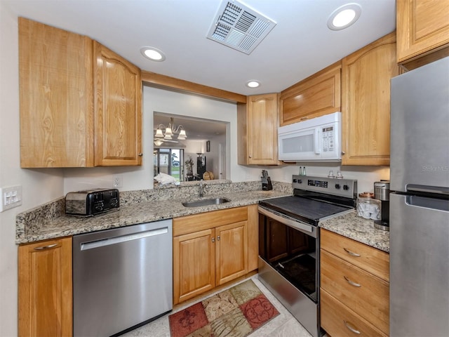 401 Airport Ave E Unit 304, Venice, FL 34285 - kitchen featuring stainless steel appliances, light stone counters, recessed lighting, and a chandelier