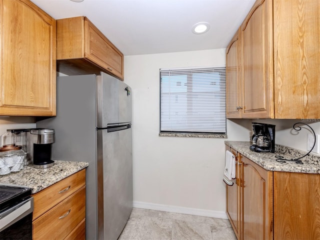 401 Airport Ave E Unit 304, Venice, FL 34285 - kitchen with freestanding refrigerator and light stone countertops