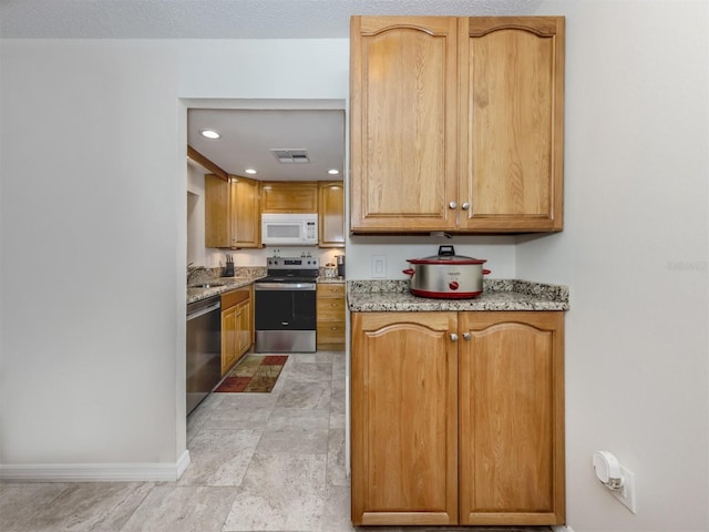 401 Airport Ave E Unit 304, Venice, FL 34285 - kitchen featuring appliances with stainless steel finishes, light stone countertops, and recessed lighting